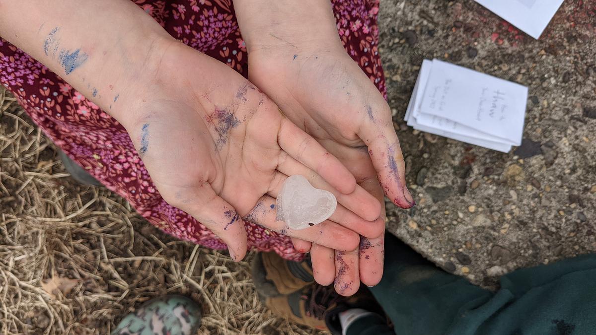 How To Thaw Your Own Heart How To Thaw Your Own Heart zine shown in a photo of a child with calendula seeds frozen into an ice heart in her hand